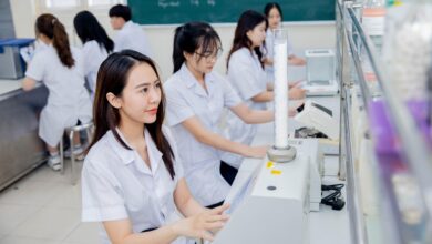 Các bạn sinh viên áo trắng đang học về dược với một loại máy